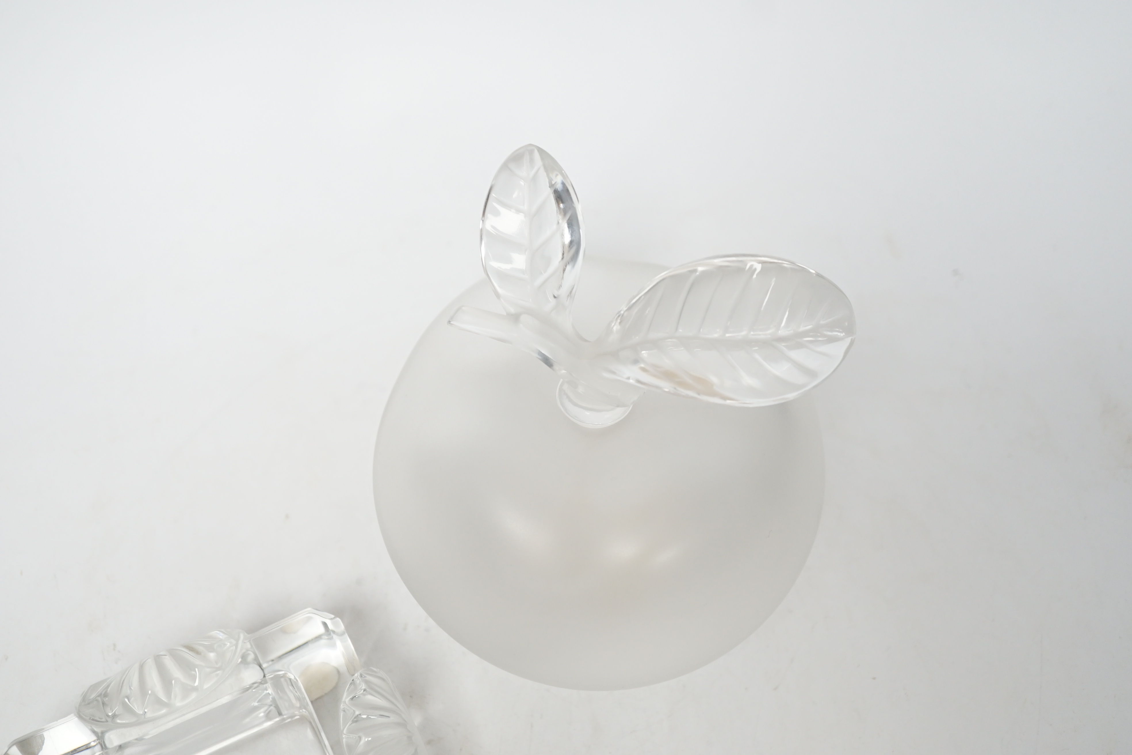 A Lalique apple shaped perfume bottle and leaf stopper together with a square ashtray, both with signed engraving to base, perfume bottle 14cm high